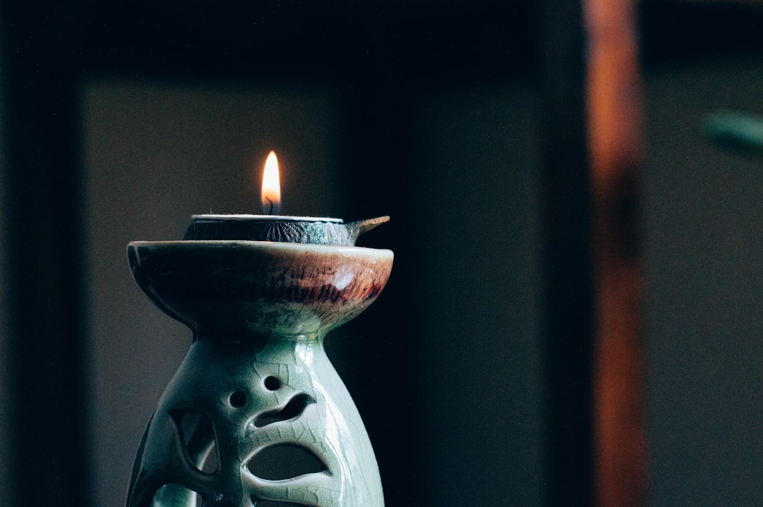 Vela encendida en vaso de barro
